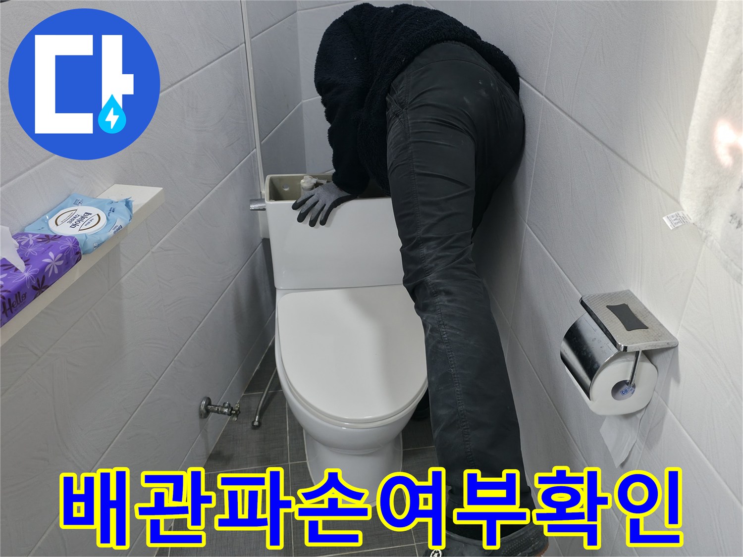 양변기 주변의 하수 및 오수 배관에 결함이 있는지 정밀 점검하는 모습