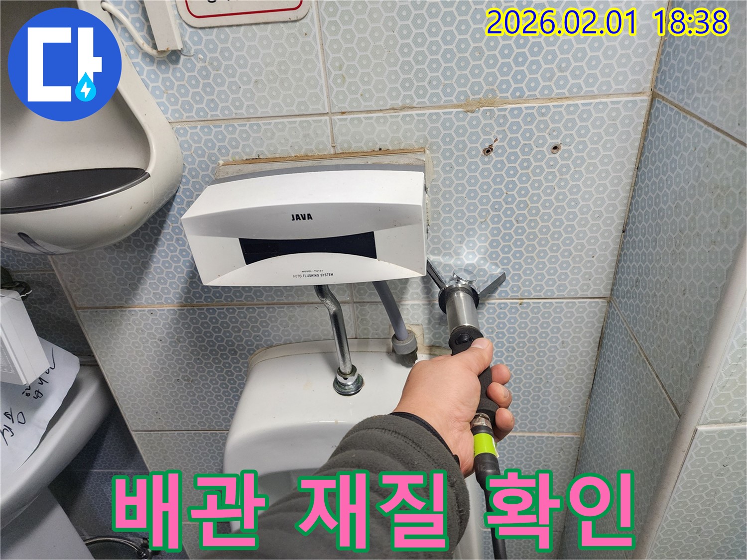소변기 배관의 재질을 확인하는 모습 - 배관 재질은 내구성과 수명에 영향을 미칩니다.