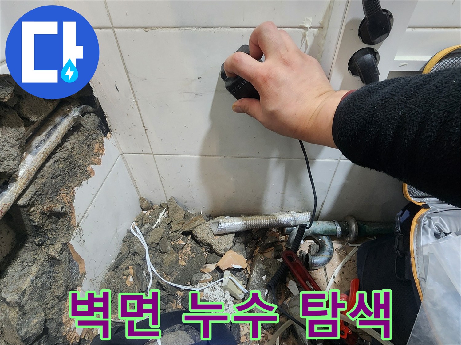 가스 탐지 장비를 벽면에 대고 미세한 누수를 찾는 작업 중입니다.