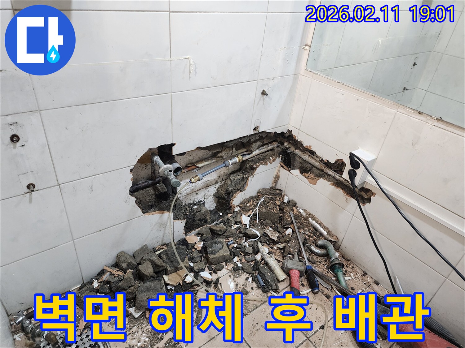용산구-누수-수리-현장에서-벽면-해체-후-벽-속-배관의-파손-부위를-보수하는-모습