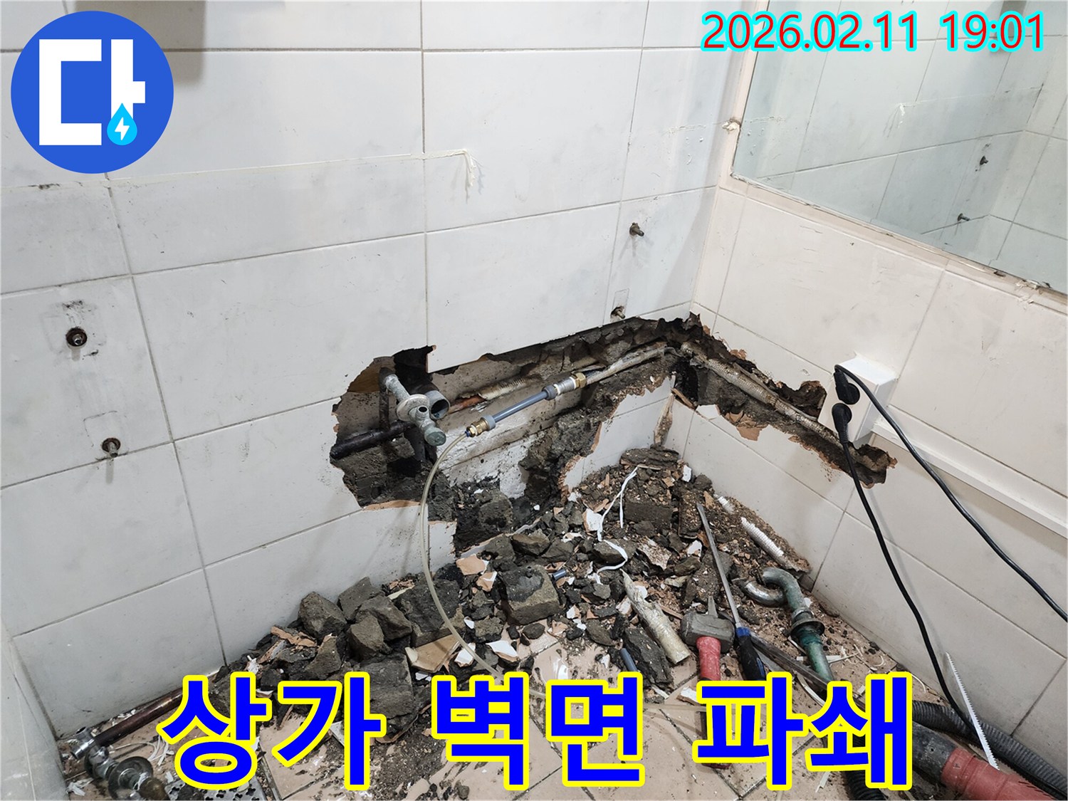 한강대로 상가의-누수 문제를 해결하기 위해-욕실 벽면을-파쇄하는-전문가의-작업 현장입니다.