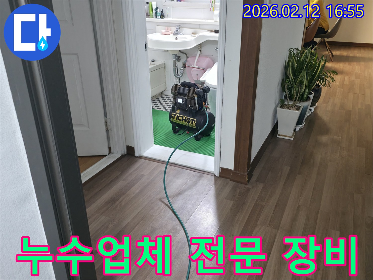 욕실 문간에-설치된 누수-탐지 장비와-연결된 호스가-바닥을 지나-믿을 수 있는-누수업체의-전문 장비-설치 모습