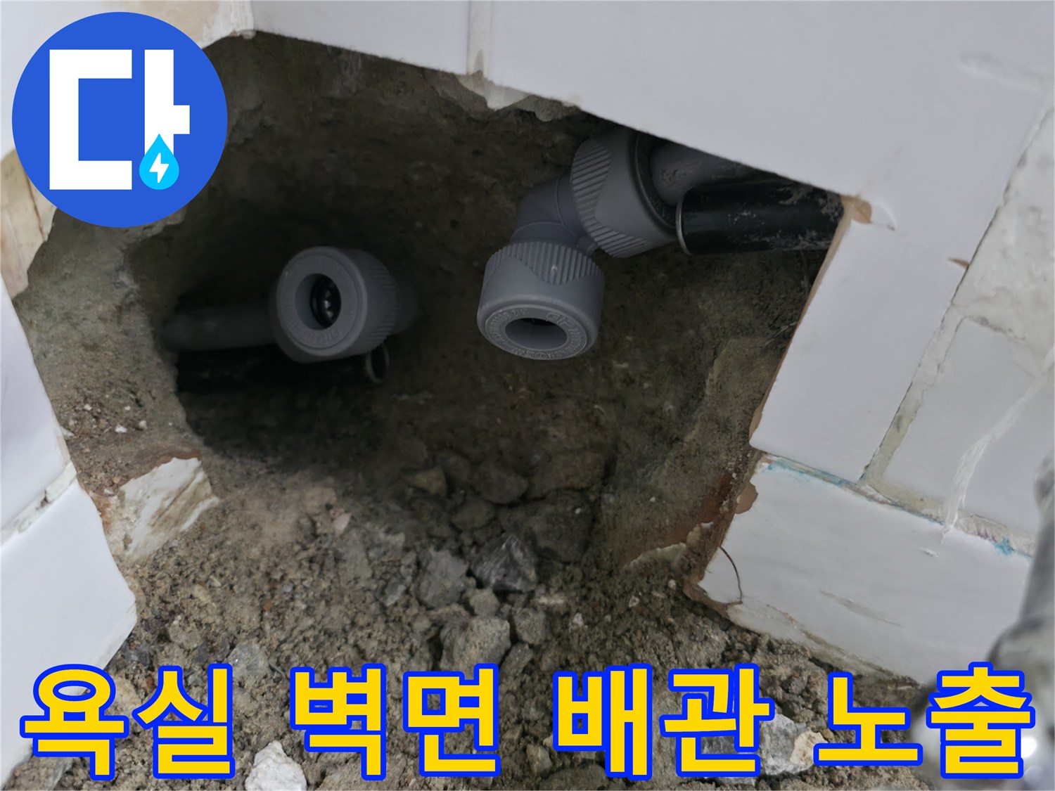 화장실 타일 내부 - 노출된 수도 배관과 연결 부위 상태