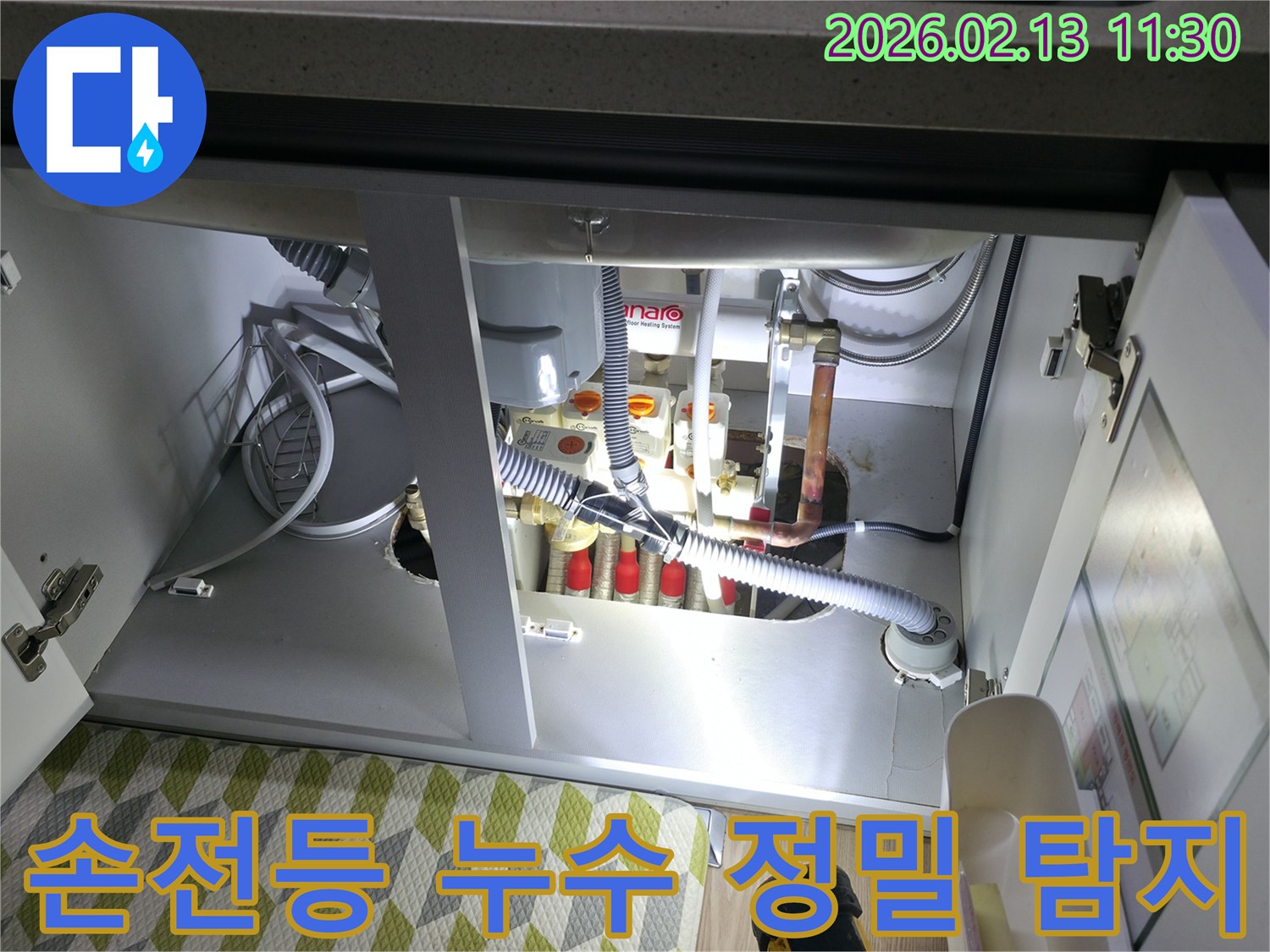 싱크대 하부의-어둡고 좁은 공간에서-손전등을 사용하여-누수 흔적을 정밀하게-탐지하는 전문가의 모습
