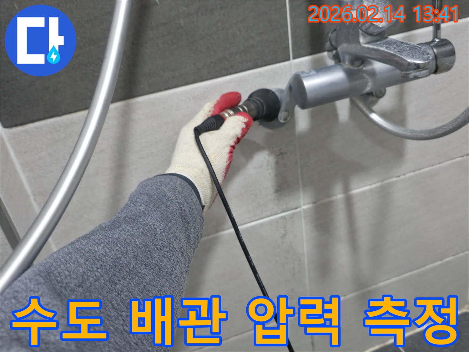 누수 전문가가-장갑을 낀 손으로-욕실 수도꼭지에-탐지 장비를 연결하여-수도 배관 압력을 측정 중입니다