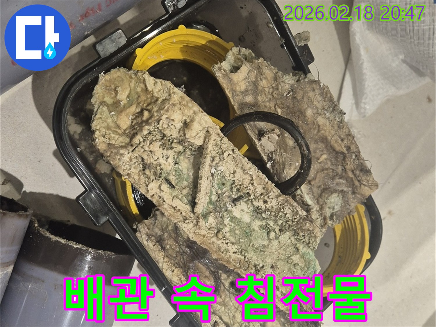 누수 공사 중-제거된 배관 내부에서-발견된 심각한 찌꺼기와-오염물을 보여주는-현장 사진입니다