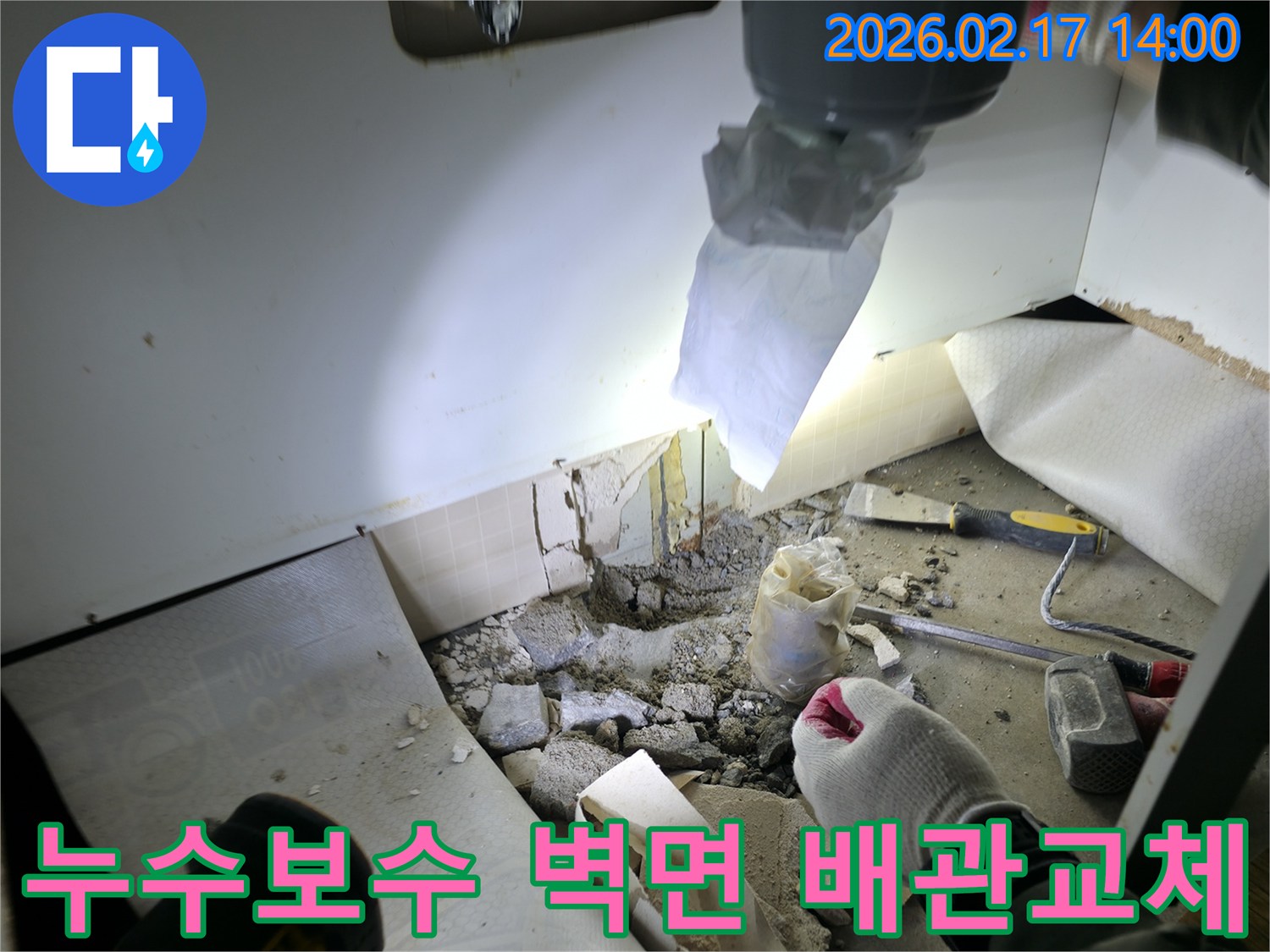 아파트 누수 보수 현장에서-벽면 파쇄 후-새로운 배관으로 교체할 준비를 하는 모습