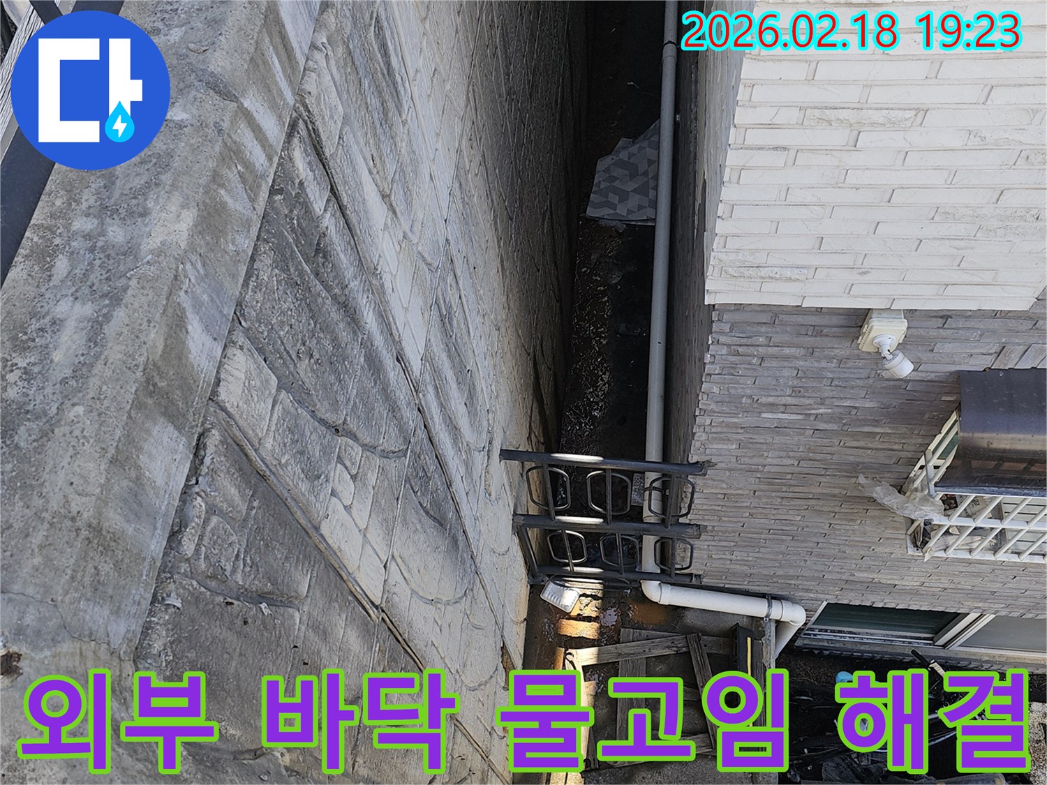 일산동구 숲속마을 주택 외부 공간 바닥면에서 발생한 물고임 현상을-해결하기 위한 방안을 모색하기 위해 전문가가 현장을 진단하는 모습입니다