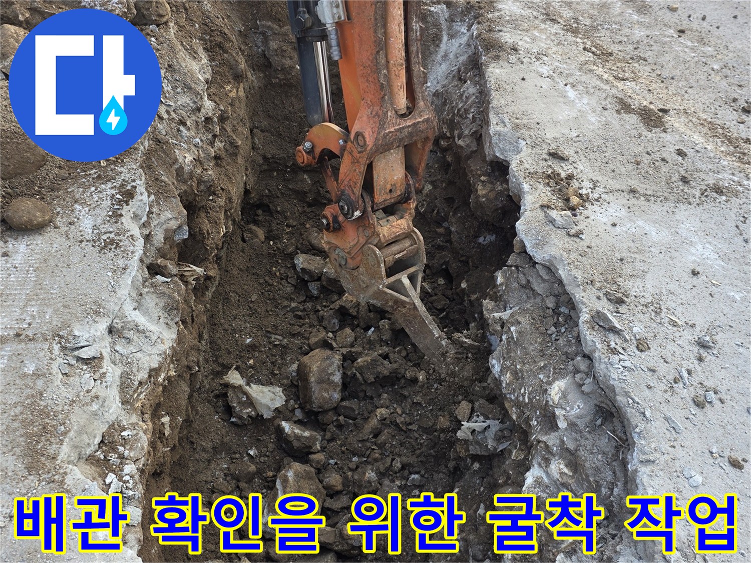 콘크리트 파쇄 후 매설된 배관을 찾기 위해 흙을 걷어내는 장면