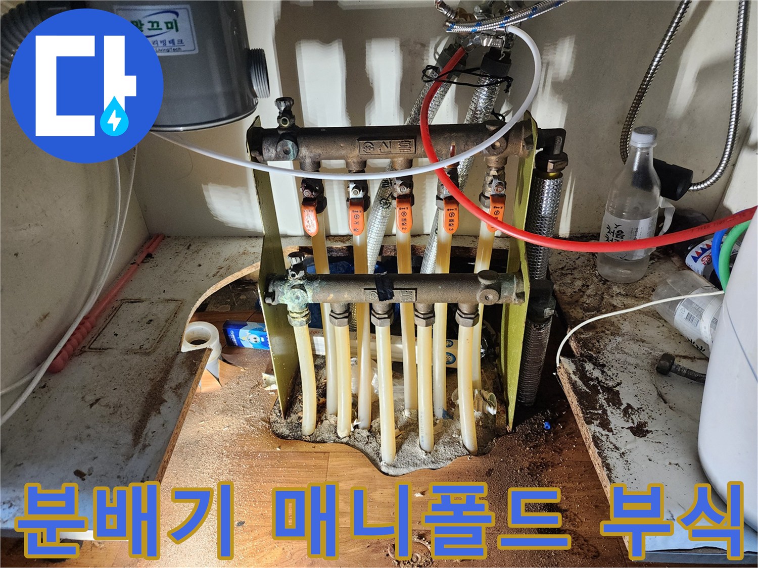 부식된 금속 분배기 몸체와 산화된 배관 연결부를 근접 촬영한 사진입니다.