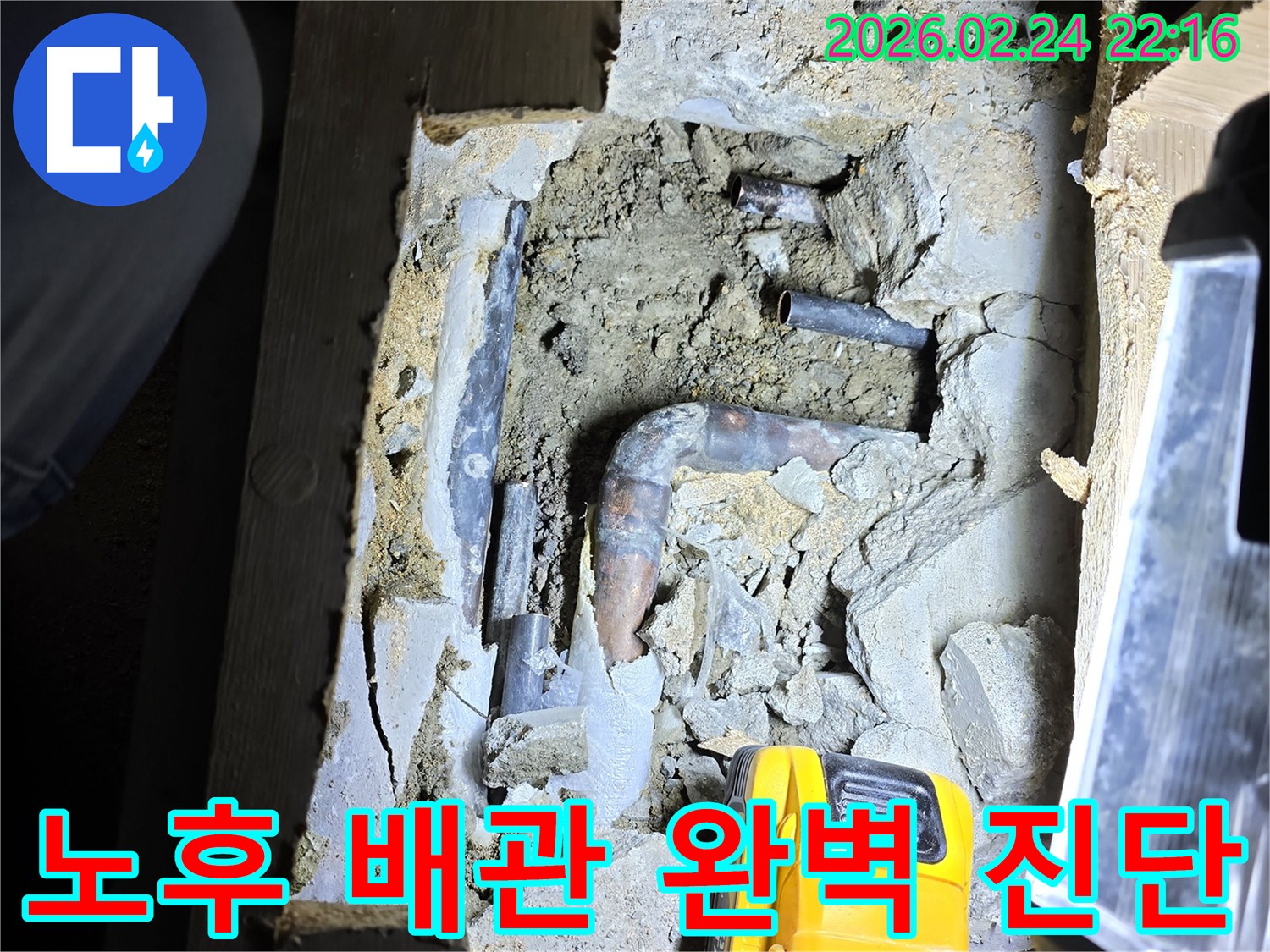 어두운 공간에서-손전등으로 비추며-노후된 수도 배관의-누수 지점을-첨단 장비로 완벽하게 진단하는-모습입니다.