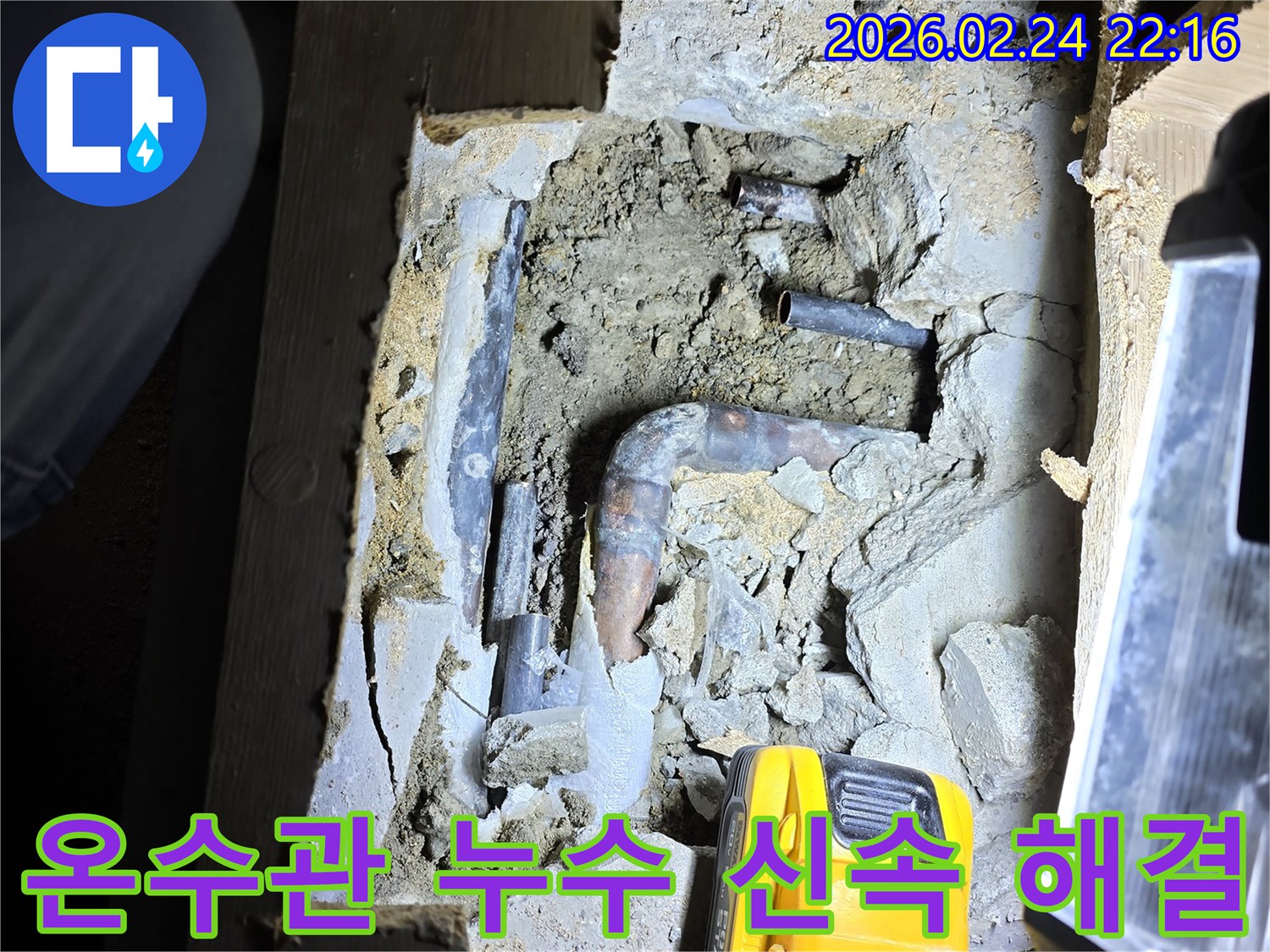어두운 공간에서-손전등으로 비추며-오래된 온수 배관의-누수 지점을-첨단 장비로 확인하고-신속한 해결을-준비하는 모습입니다.