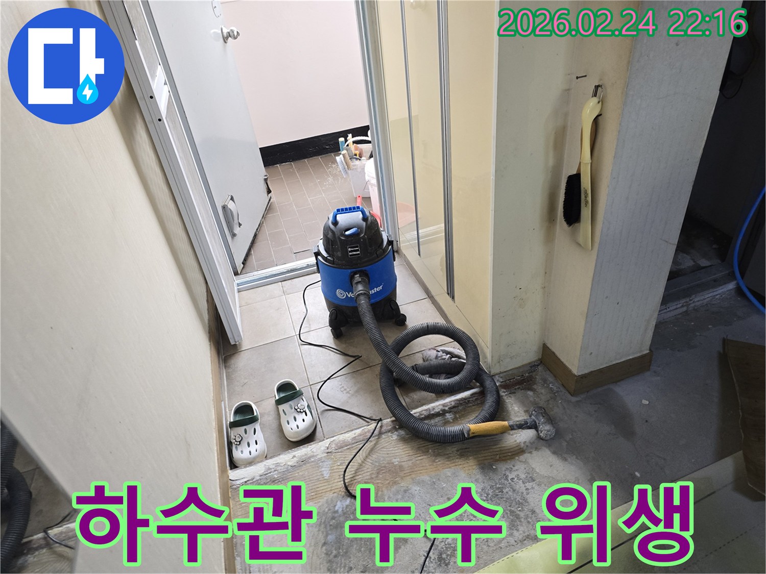 하수관 누수 현장에서-위생적인 환경을 위해-젖은 바닥의 물기를-습식 청소기로 제거하는 작업