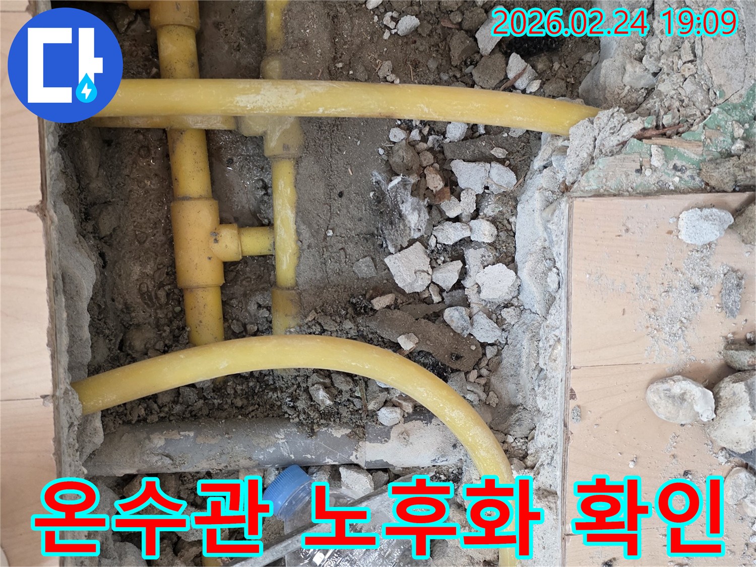 온수관 누수 해결을 위해 바닥을 파쇄하고-노출된 온수 배관의 노후화 상태를-정밀하게 확인하는 작업 현장입니다.