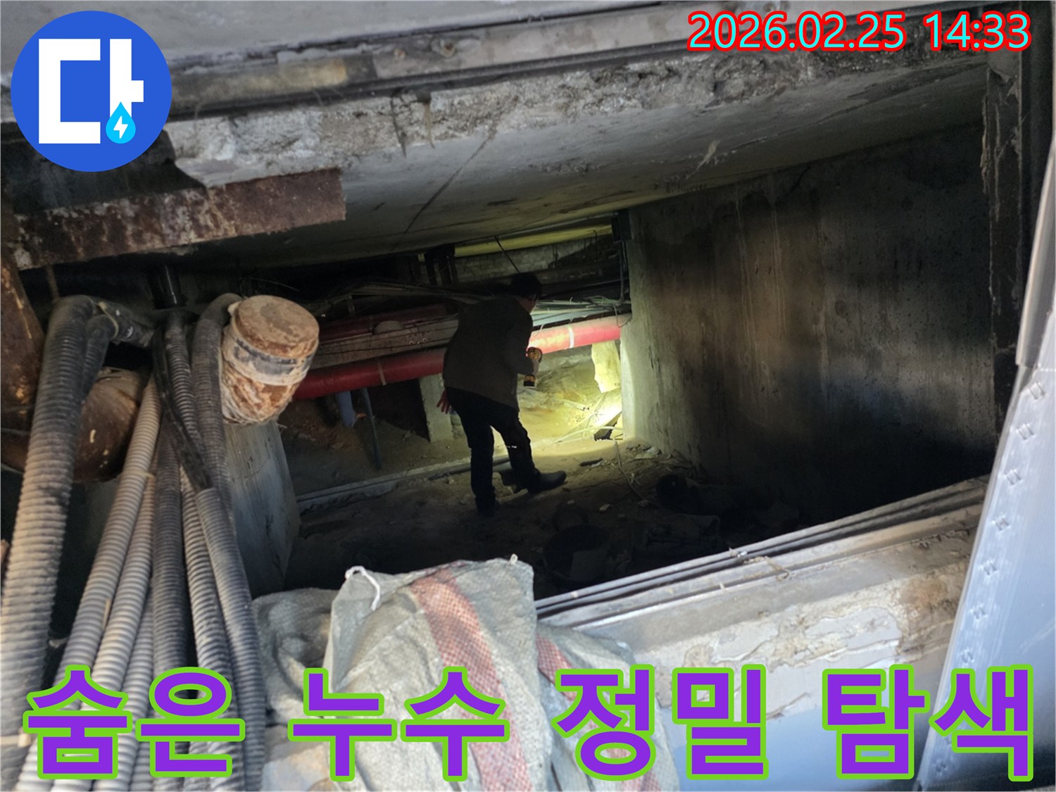 누수 엔지니어가-어둡고 좁은 공간에서-손전등으로-배관을-꼼꼼히-살피는 모습