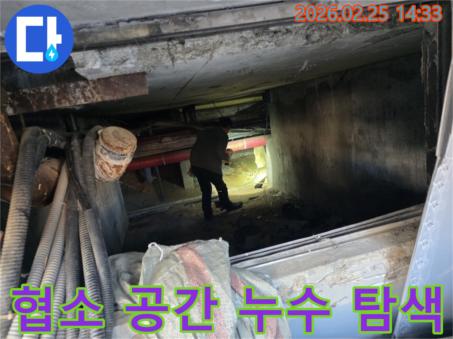 누수 엔지니어가-어둡고 좁은 지하 통로에서-손전등으로-배관을-꼼꼼히-살피는 모습