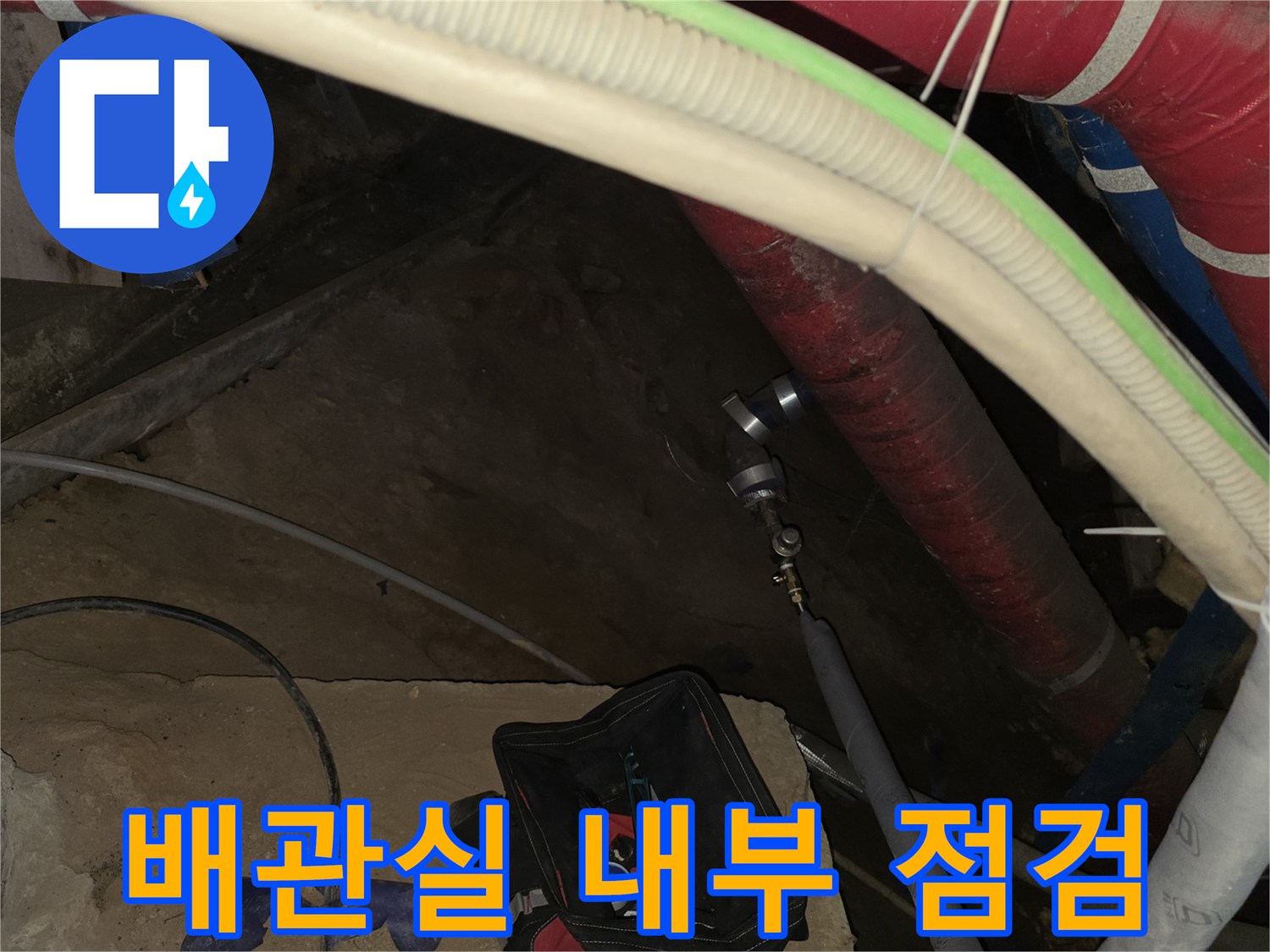보온재가 씌워진 배관과 금속 부속품이 보이는 지하 공간