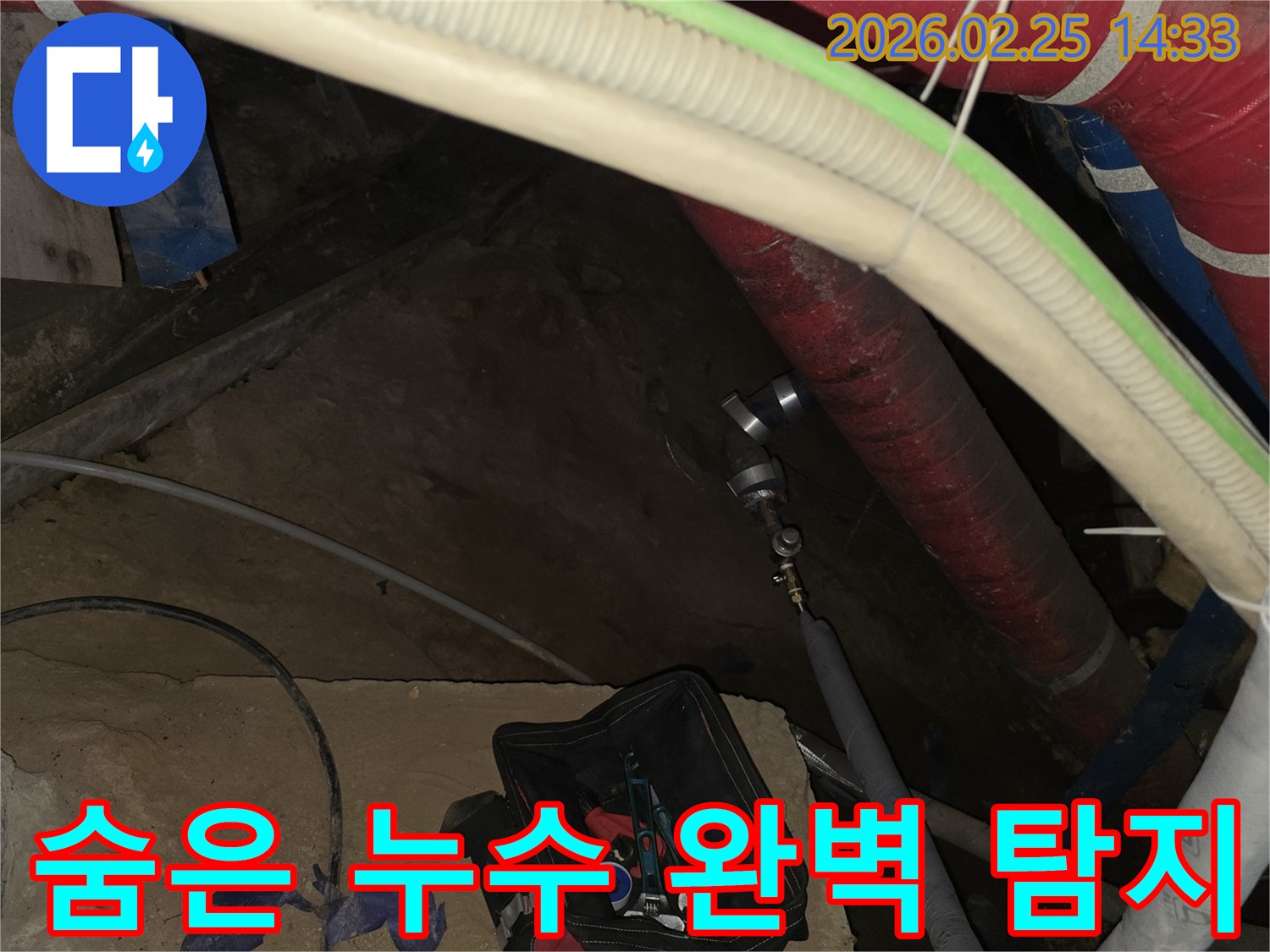보이지 않는 곳의 누수까지 완벽하게 찾아내기 위해-배관에 정밀 탐지 장비를 연결하는-전문가의 작업 현장입니다.