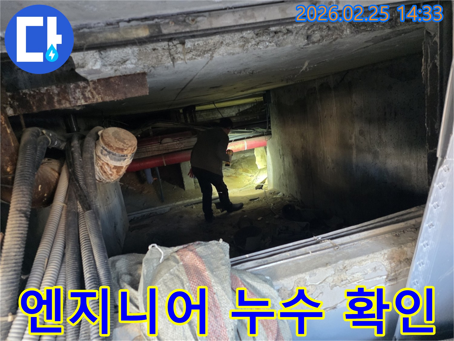 손전등을 든-누수 전문가가-복잡한 배관 사이에서-누수 지점을-확인하는 중