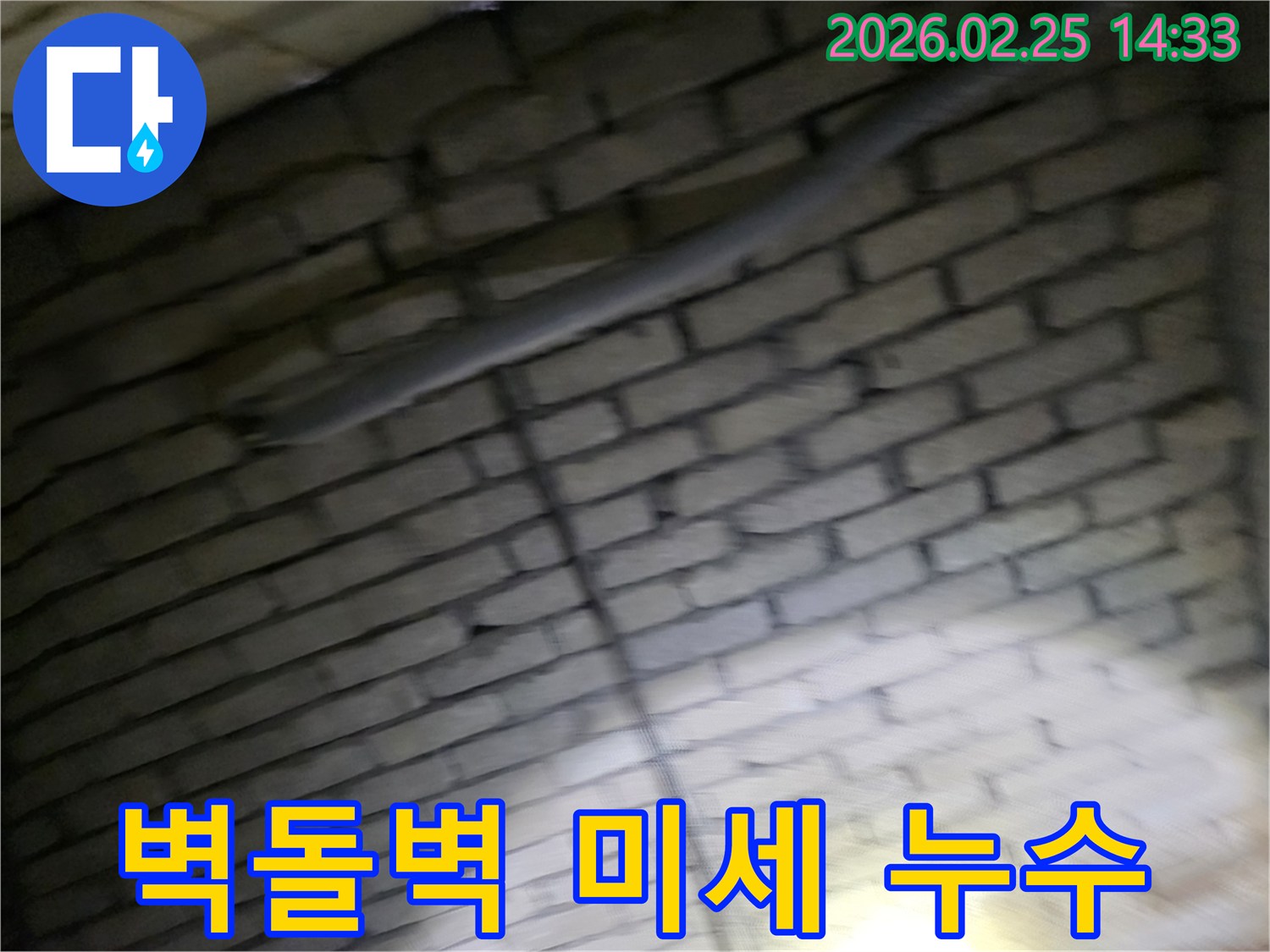 어두운-벽돌벽-안쪽-배관에서-발생한-미세-누수를-정밀-장비로-탐지하는-전문가의-모습-육안으로-찾기-어려운-누수-지점-확인