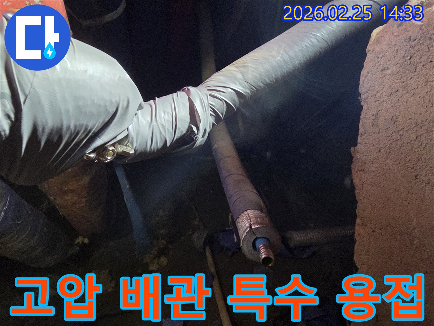 어두운 작업 공간에서-장갑을 낀 손이-고압 배관의-손상된 부분을-특수 용접으로-견고하게 보수하는-모습을 담고 있습니다