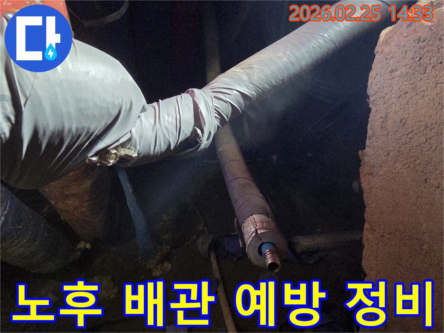 어두운 작업 공간에서-장갑을 낀 손이-오래된 배관의-손상 정도를-면밀히 진단하며-누수 예방을 위한-정비 작업을-진행하는 모습입니다