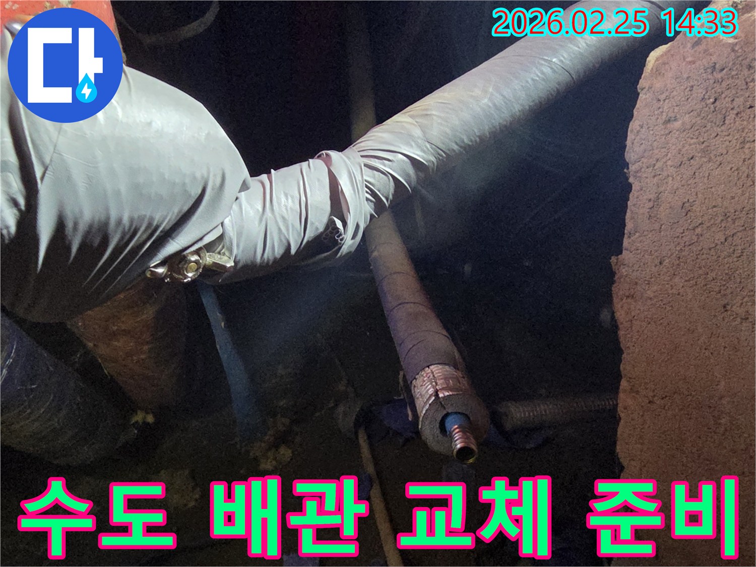 어두운 작업 환경에서-장갑을 낀 손이-오래된 수도 배관을-새로운 배관으로-교체하기 위해-정교하게 준비하는-모습을 담고 있습니다