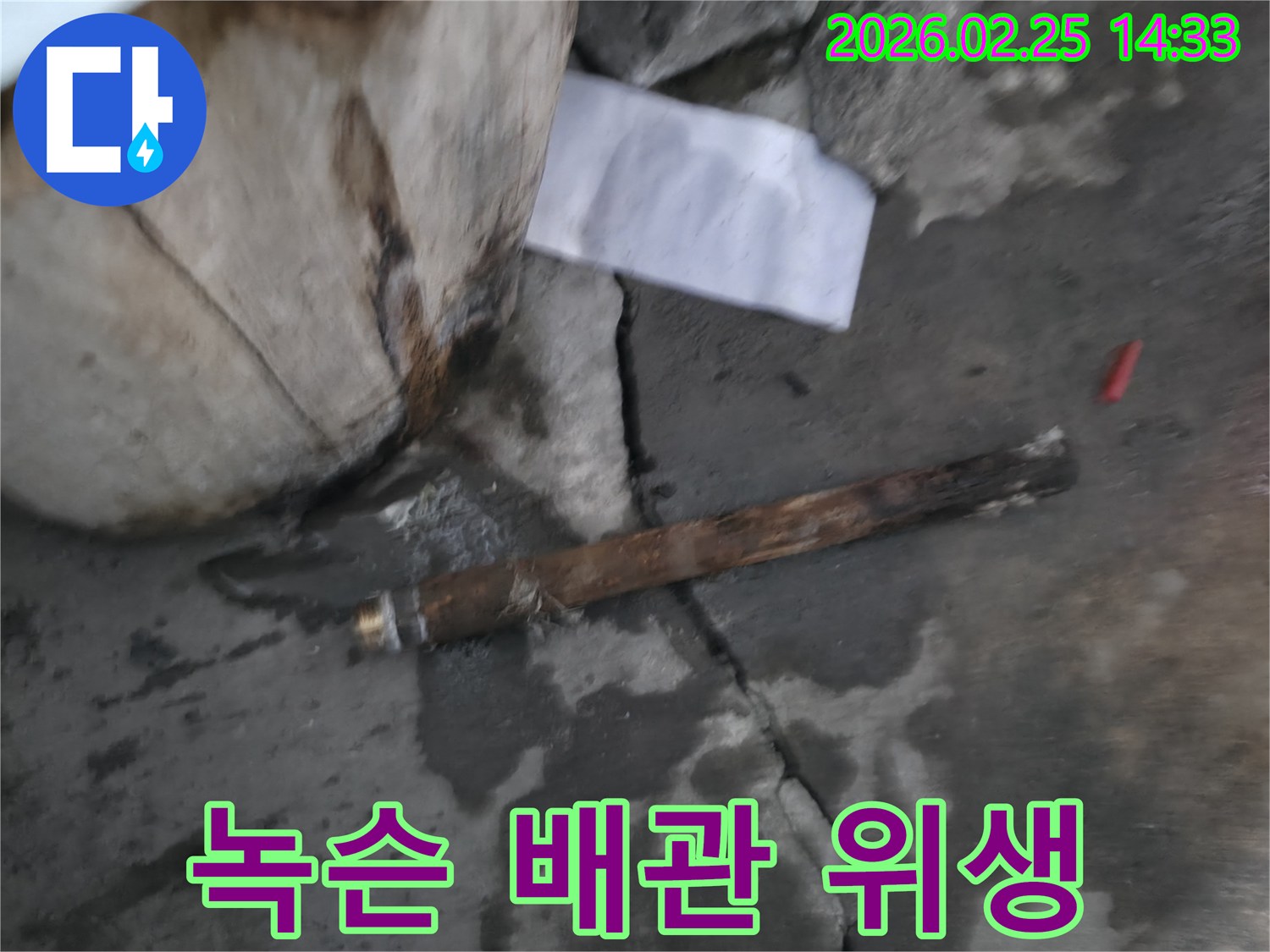 오래되어 녹슬고-부식된 배관이-젖은 바닥에 놓여있는-누수 공사 현장 사진입니다.