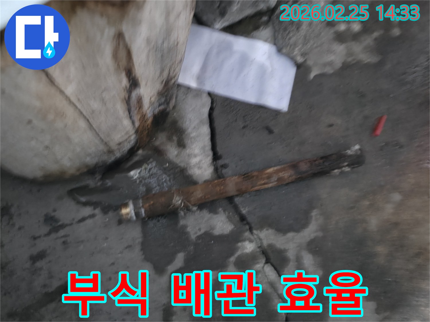 오래되어 부식된-파열된 배관이-젖은 바닥에 놓여있는-누수 공사 현장 사진입니다.
