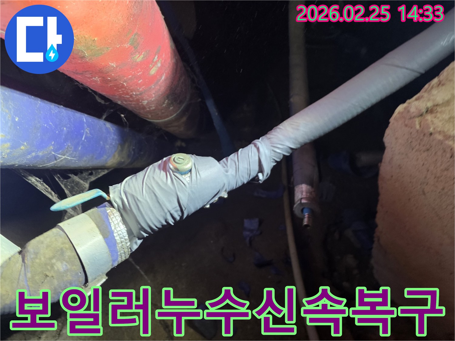 이 이미지는 누수 탐지를 위해 배관에 압력 측정 장비를 연결하는 전문 엔지니어의 모습을 보여줍니다-정확한 누수 지점을 찾기 위한 핵심 과정입니다