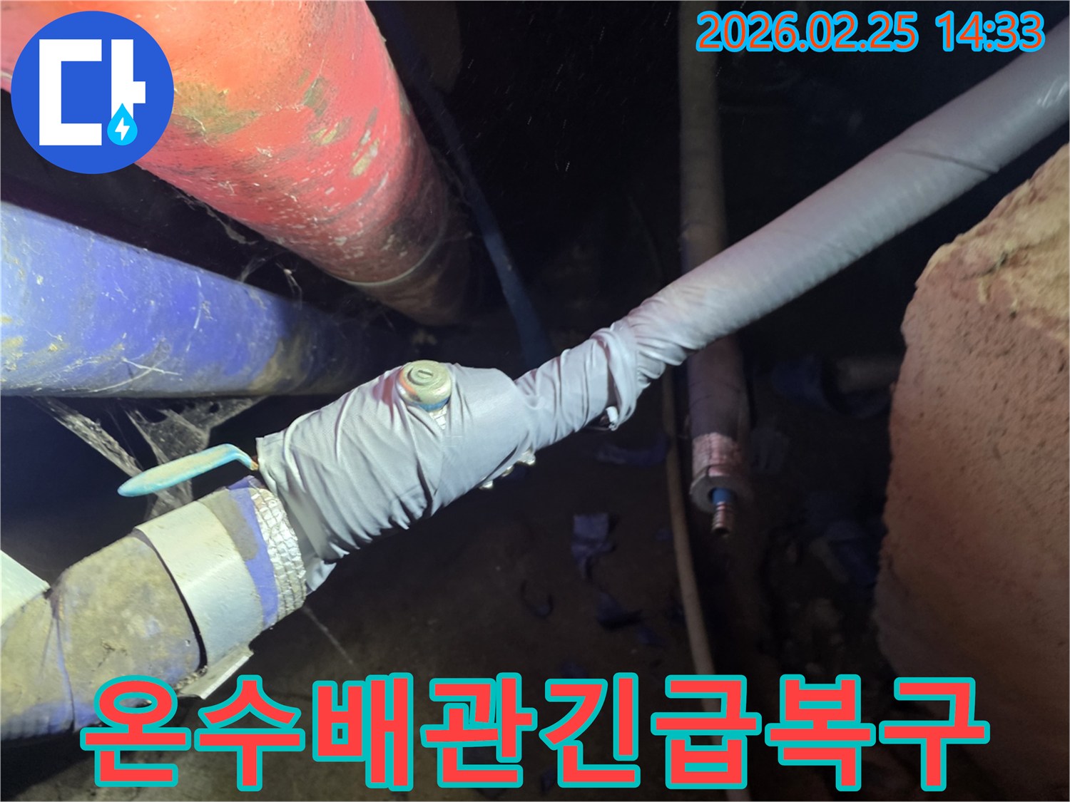 이 이미지는 누수 탐지를 위해 온수 배관에 압력 측정 장비를 연결하는 전문 엔지니어의 모습을 보여줍니다-정확한 누수 지점을 찾아 신속하게 복구합니다