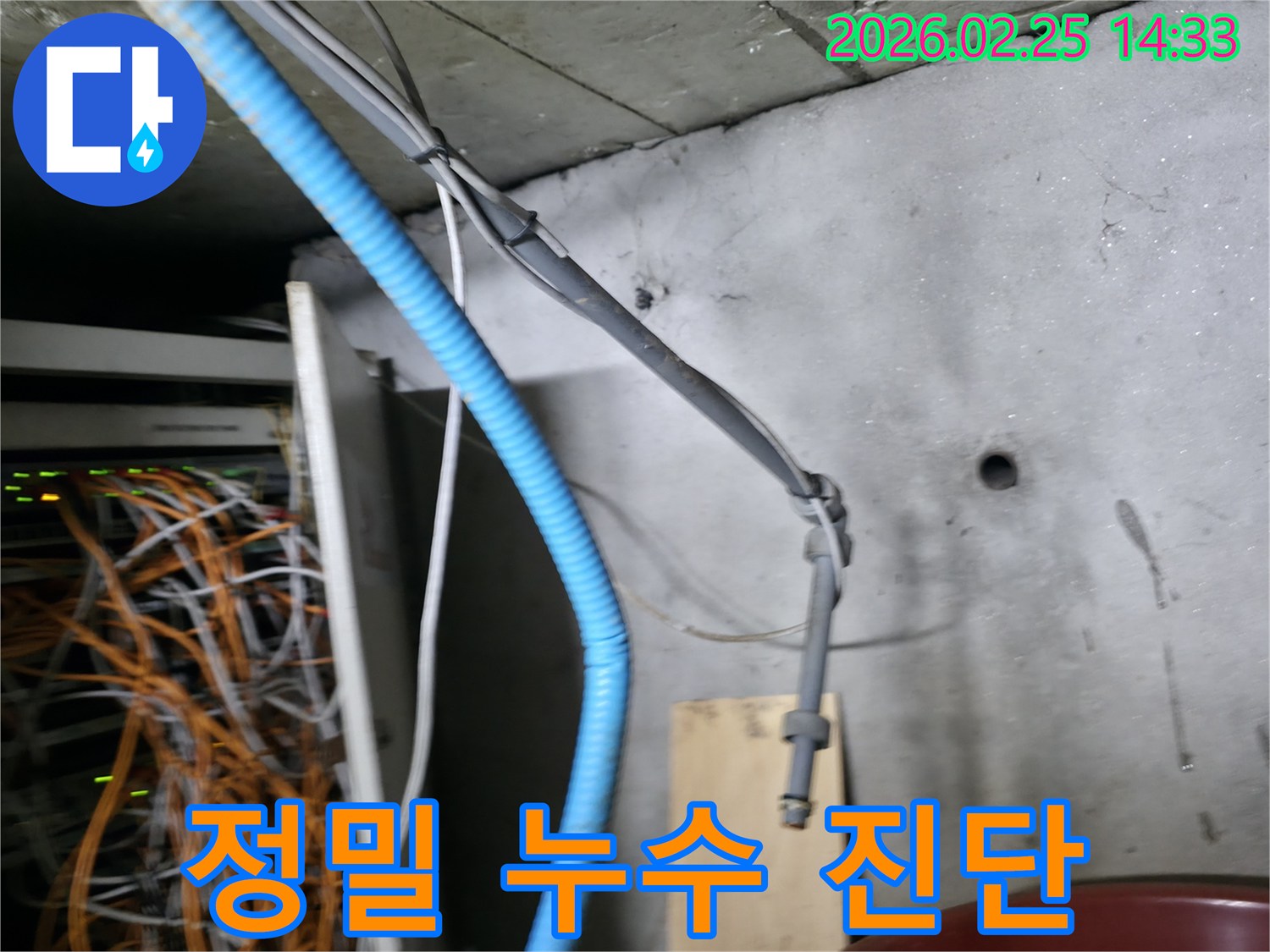 이 이미지는 누수 현장에서-복잡하게 얽힌 배관과 케이블을-첨단 장비로 정밀하게 진단하는-전문가의 모습을 보여줍니다