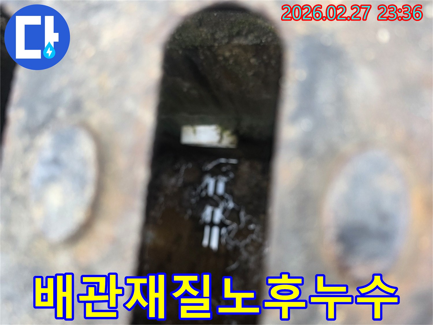 녹슨-철제-배수구-아래-고인-물과-물속에-잠긴-오래된-배관-재질이-보이는-누수-현장