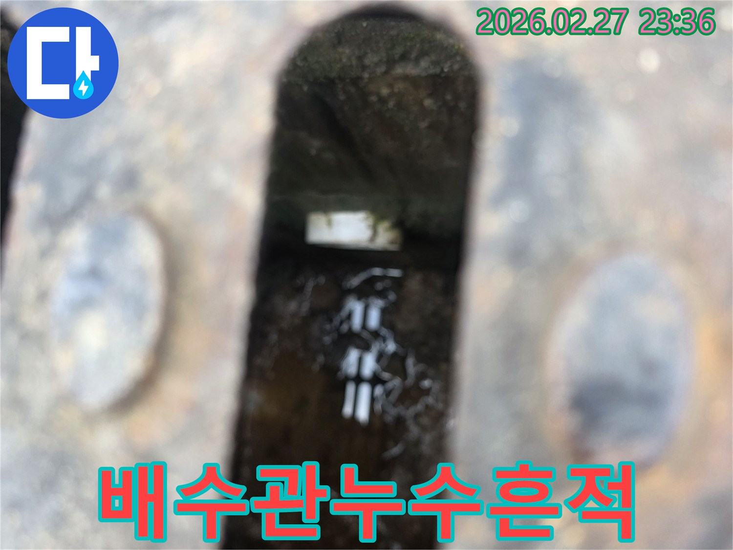 녹슨-철제-배수구-아래-고인-물과-물에-잠긴-배관-일부가-보이는-누수-현장-사진