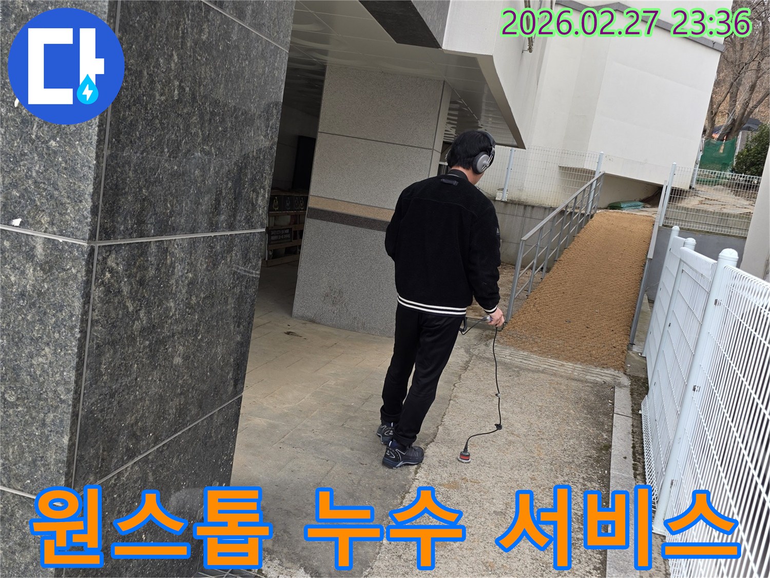 누수 엔지니어가-청음식 탐지 장비로-건물 외부의-누수 지점을 찾아내어-원스톱 해결의 첫 단계를 수행하는 모습