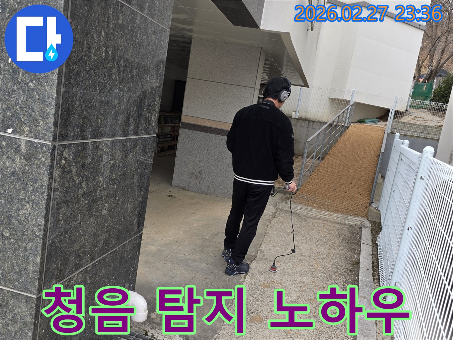 누수 전문가가-청음식 탐지 장비로-건물 외부에서-누수음을 분석하는-숙련된 노하우를 보여주는 모습