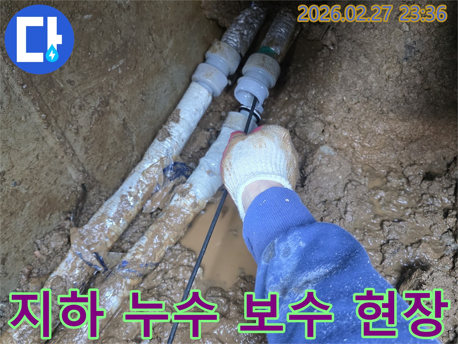 흙 속에 묻힌 수도관에서 발생한 누수를-전문가가 정밀하게 보수하는 현장 사진입니다