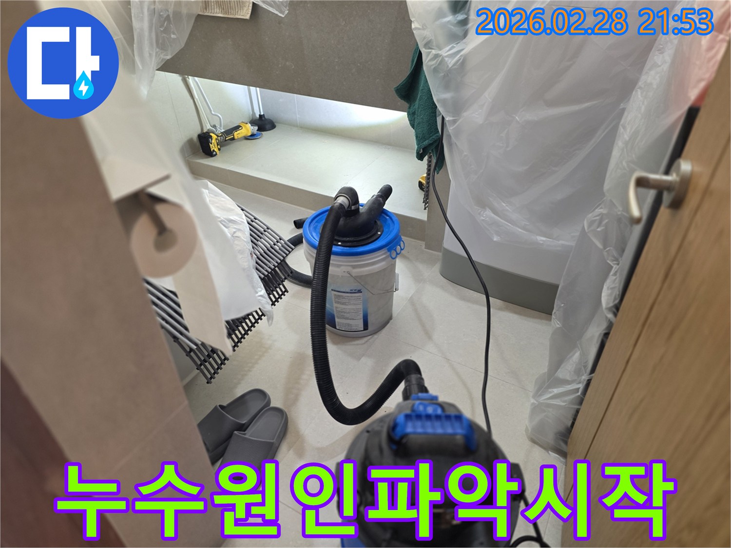 이 이미지는 누수 원인을 파악하기 위한 첫 단계로-주변을 비닐로 보양하고-습식 청소 장비를 설치하여-물기를 제거하는 현장을 보여줍니다.