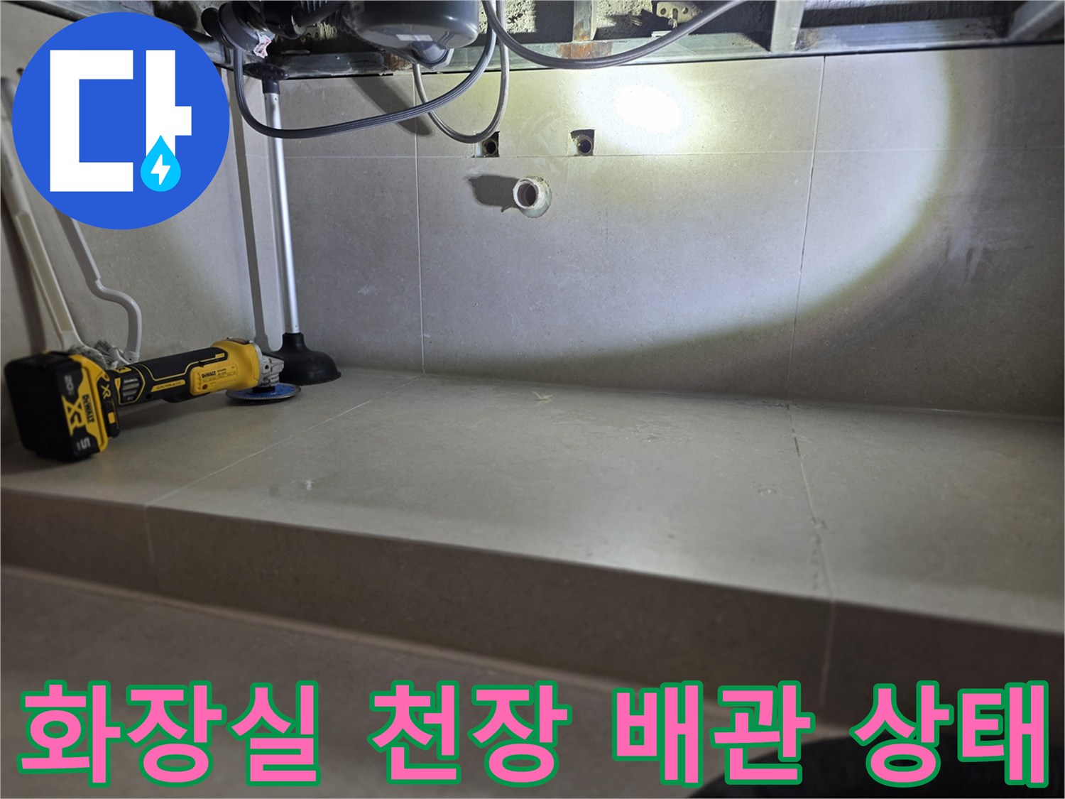 화장실 천장 내부-노출된 배관과 드릴 작업 현장