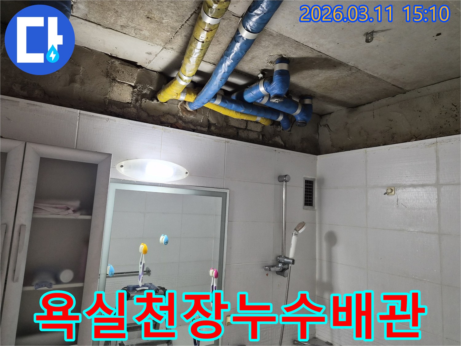 욕실 천장에서-파란색과 노란색-단열 배관이-노출된 채-누수 점검 중인-현장 사진입니다