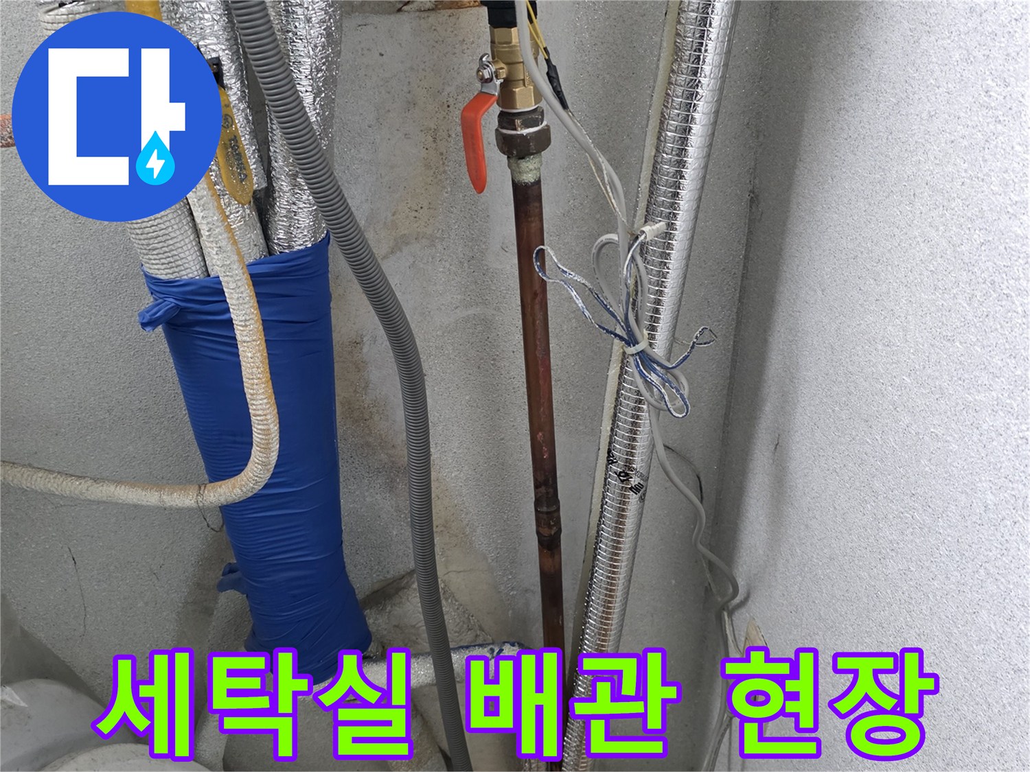 은색 보온재와 파란색 보충재로 마감된 세탁실 내부 배관 시설의 사진입니다.