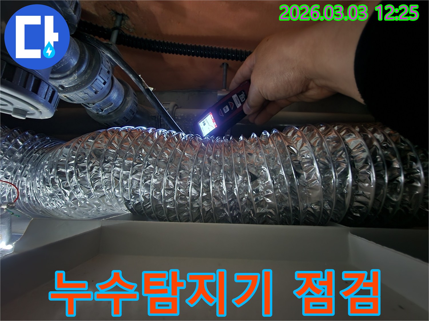 누수 전문가가-정밀 탐지기로-숨겨진 배관의 습기나-온도 변화를 감지하여-누수 원인을 찾는 모습