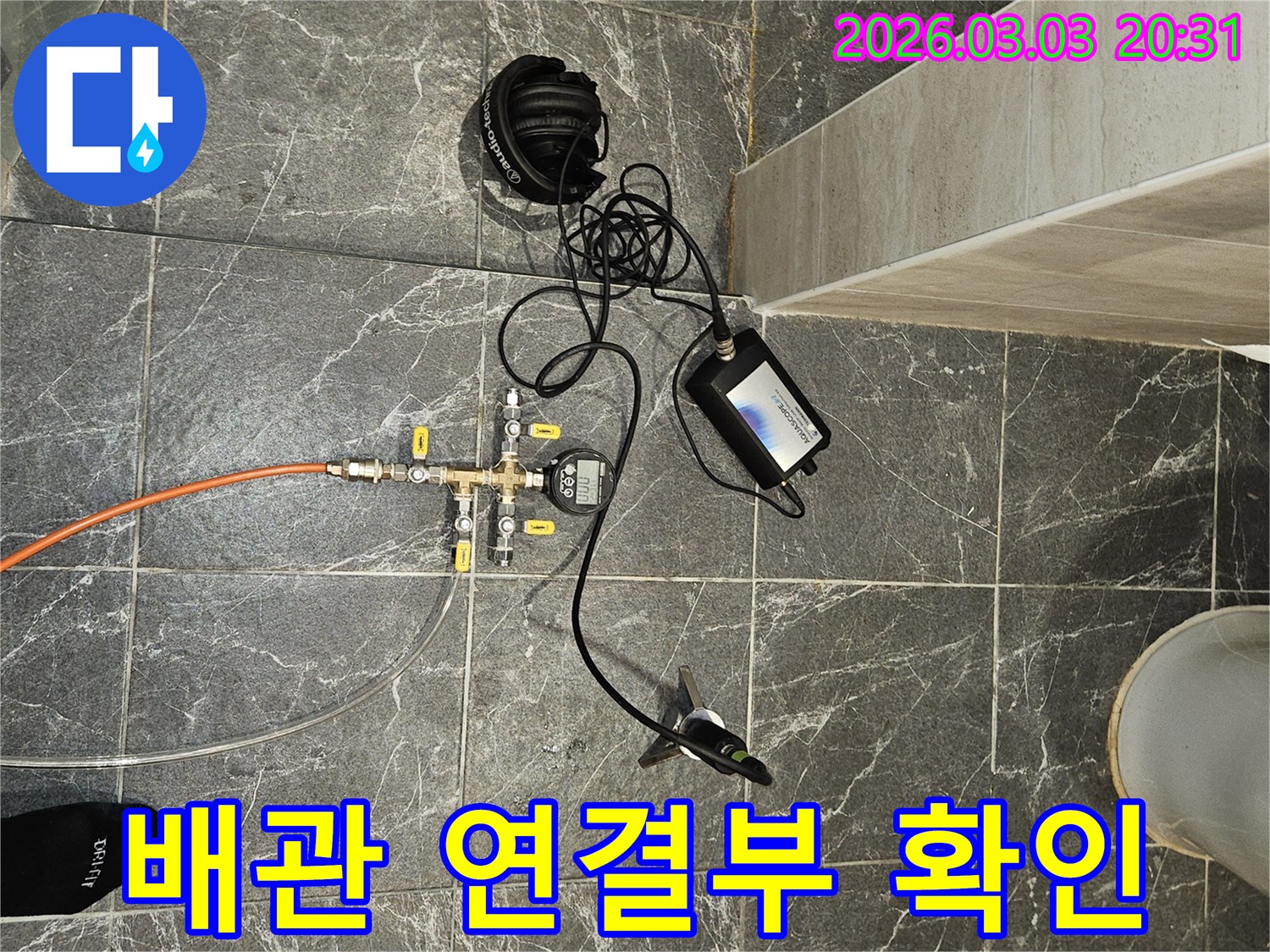 누수 탐지 장비를 배관 연결부에-정밀하게 연결하고-누수 여부를 확인하는 현장입니다.