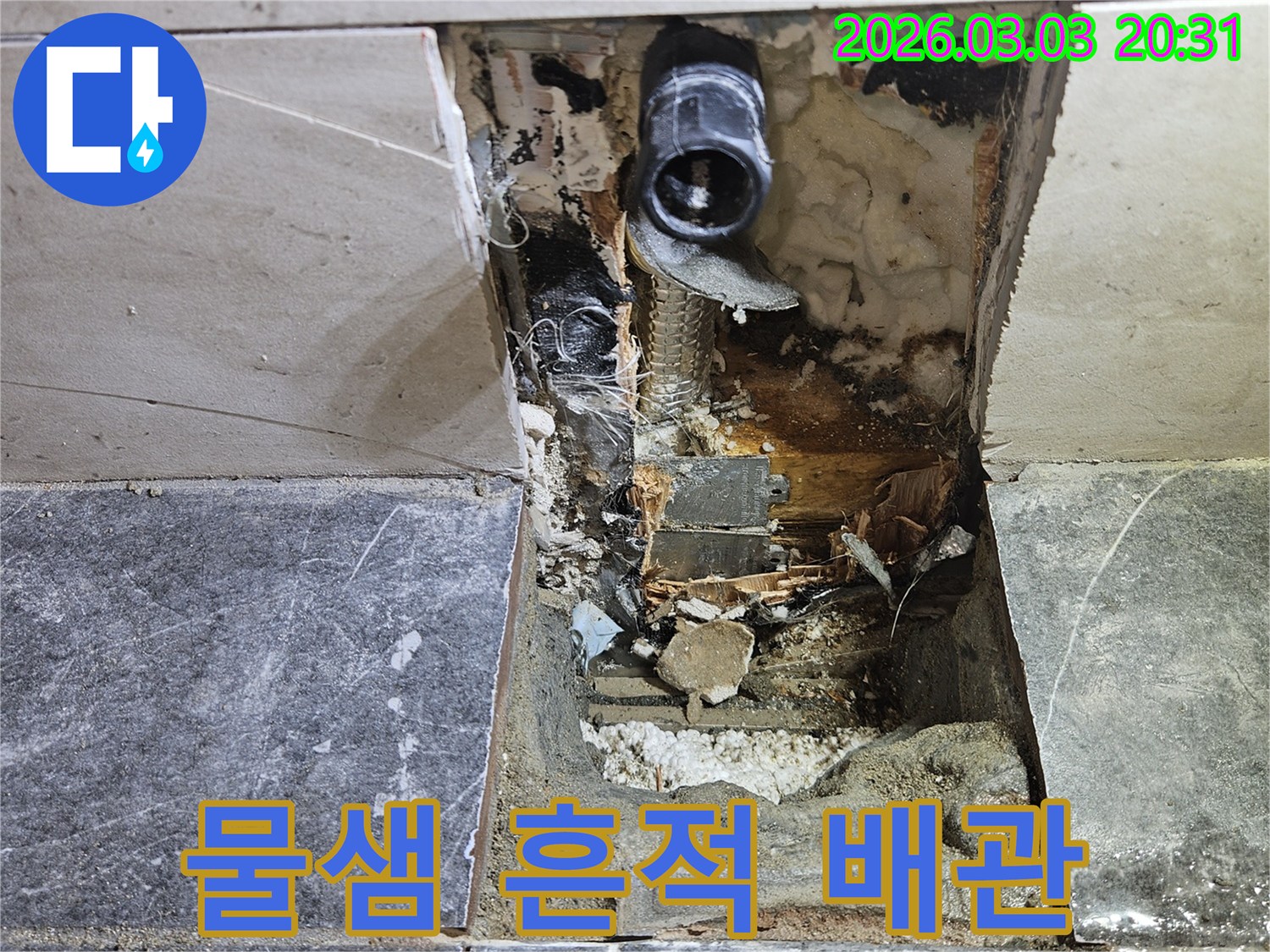 벽면 타일이 제거된 후 드러난 공간에서-배관 주변에 물이 새어 나온 명확한 흔적들이 보이는 공사 현장