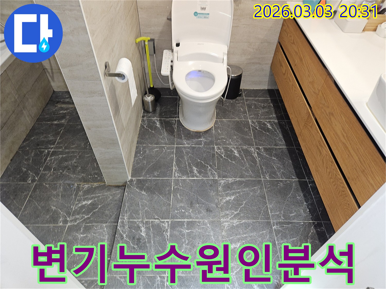 어두운 회색 타일로 마감된-현대적인 화장실 내부-변기와 비데가 설치된 모습입니다.