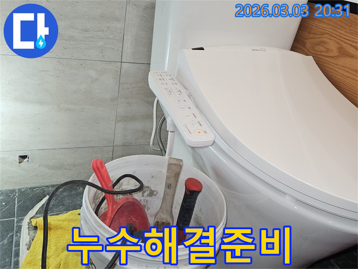 이 사진은-변기 옆에 놓인 작업 도구들을 통해-화장실 누수 문제를 해결하기 위한-준비 과정을 보여줍니다.