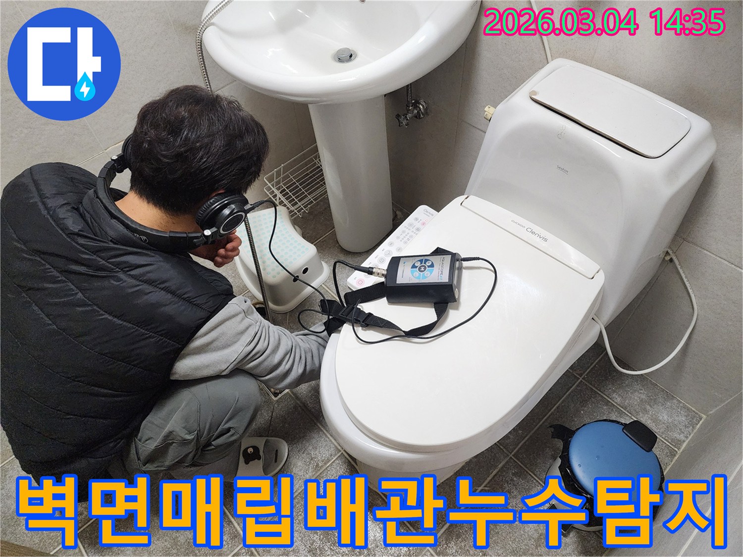 숙련된-엔지니어가-헤드폰을-착용하고-화장실-변기-옆-벽면에서-매립된-배관의-누수-여부를-정밀하게-탐지하는-모습
