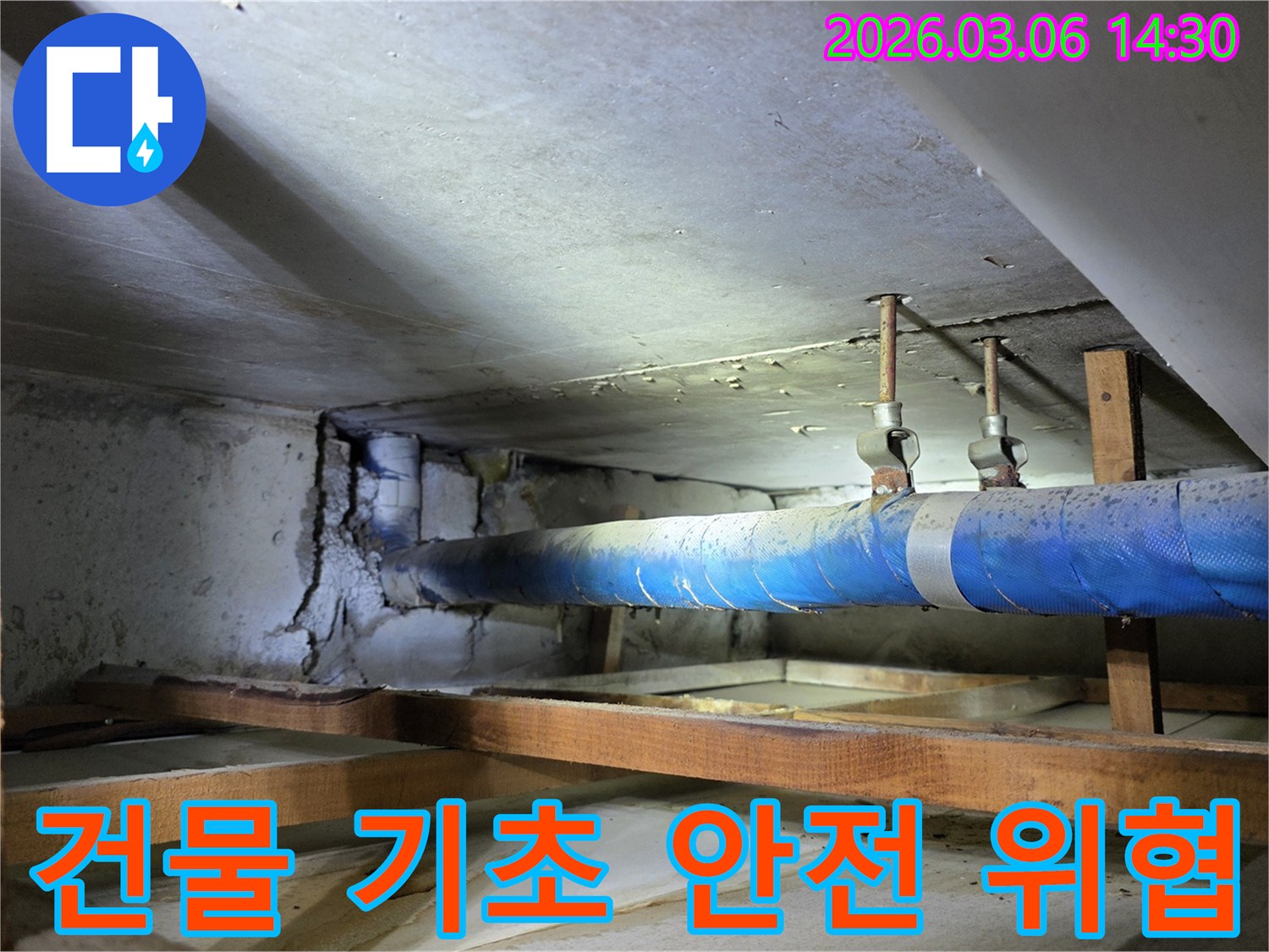 지하 공간의 파란색 배관 옆-누수로 인해 심각하게 손상된-콘크리트 벽면이-건물 기초 안전을 위협하는-현장 사진