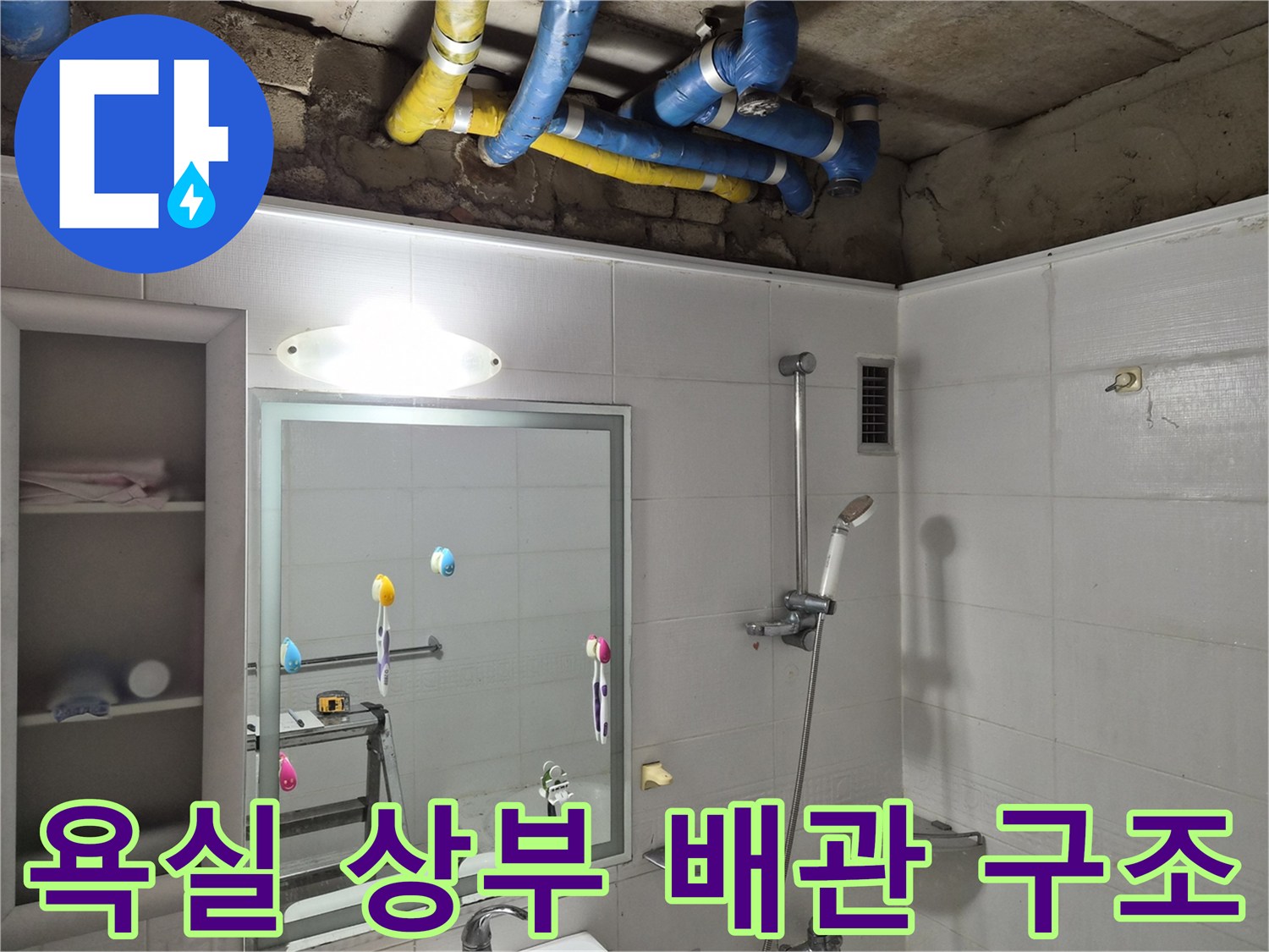 천장 점검구 내부의 파란색과 노란색 배관 부위 상세 사진