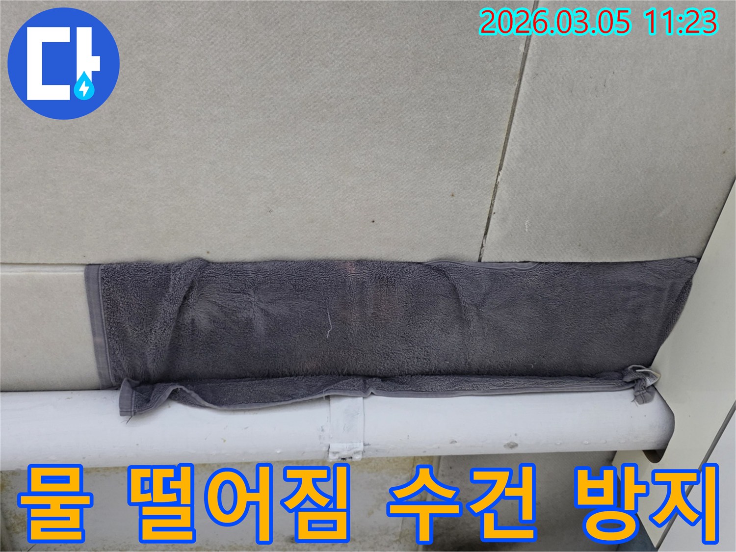 누수 지점에서 물이 떨어지는 것을-수건으로 받아내고 있는 상황-고객님의 빠른 대처가 돋보입니다